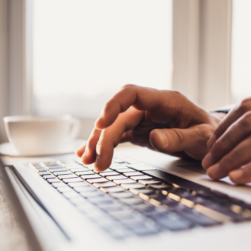 Hands typing on a laptop.